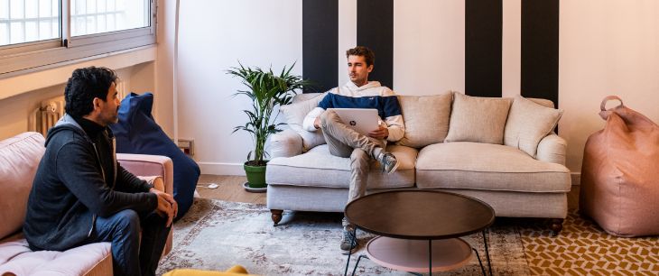 Deux coworkers en pleine discussion dans un espace convivial et chaleureux de coworking